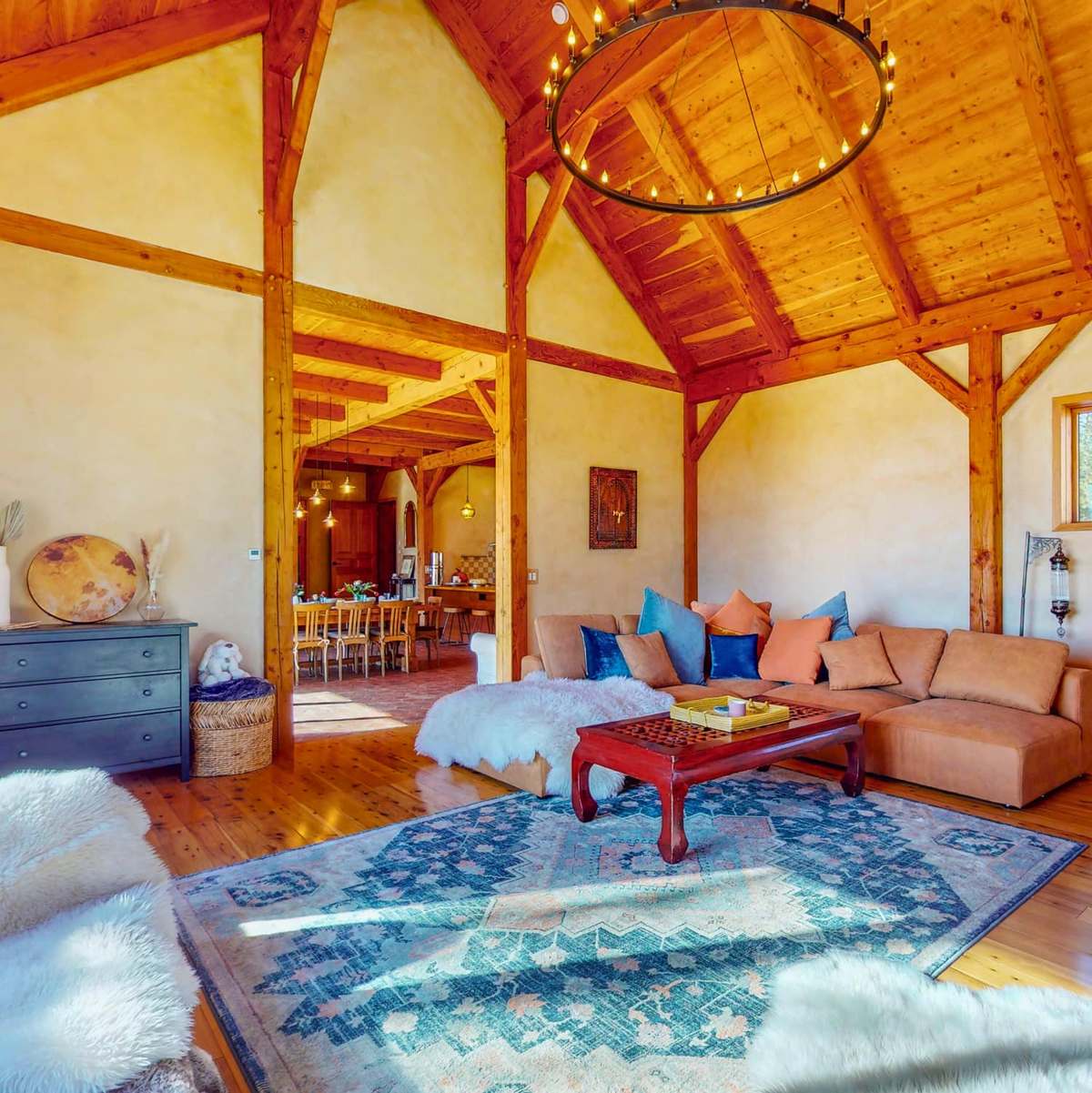 Timber-frame living room with floor cushions and rugs