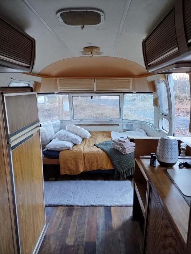 Inside the restored Airstream, bed made