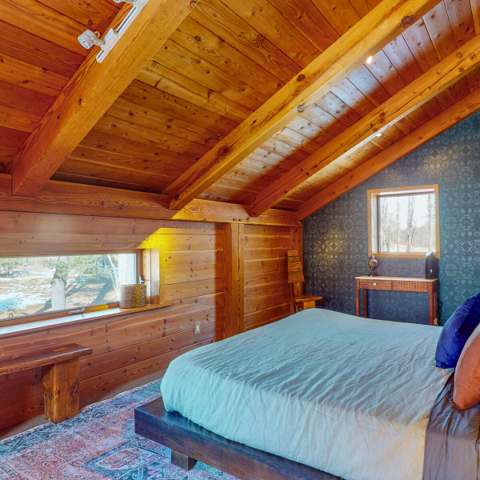 Timber loft bedroom with a view over the land